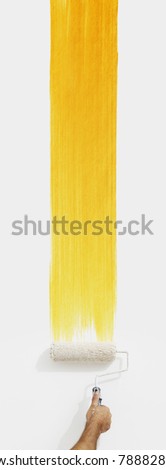 hand with paint roller painting color yellow, close up  isolated on blank white wall background