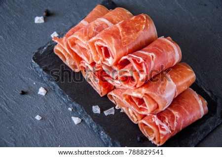 Typical Jamon Iberico ham from Spain on a gray background.
