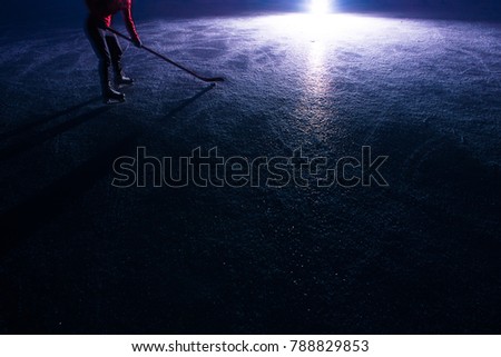 Hockey equipment - stick and hockey player on ice in dark 