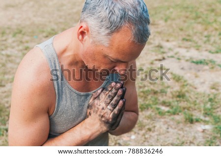 Man pray for god under heaven hope light : hope concept. Dirty hands clasped together for a prayer. Man praying with his head down and hands together, alone in nature. God please help me! 