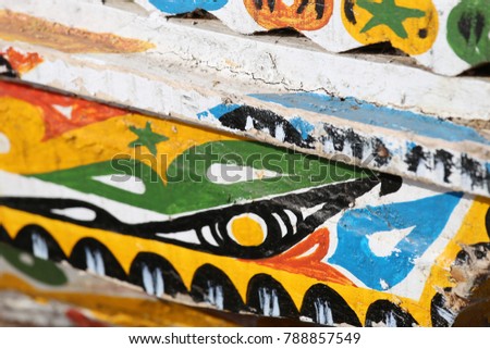 Details of colored wooden boats. Colorful planks of senegalese traditional boats. Patterns of bright colors used to paint the wood. Letters and lines and curves are painted for decoration.