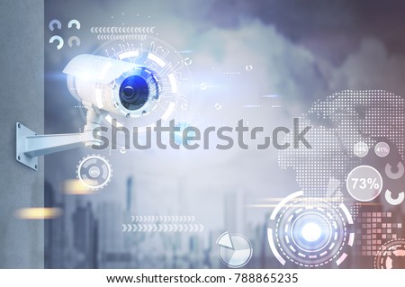 Modern CCTV camera on a wall. A foggy day in a city background with abstract infographics and HUD. Toned image double exposure mock up Royalty-Free Stock Photo #788865235