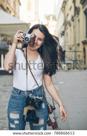 portrait of young pretty woman with retro camera  outside 