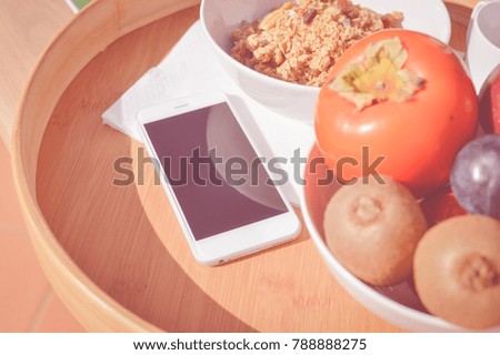 Close up on mobile phone and healthy breakfast modern lifestyle background. Top view mock up flat lay