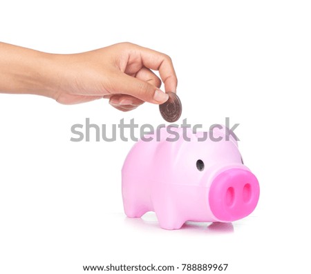 Inserting a coin into a piggy bank isolated on white background