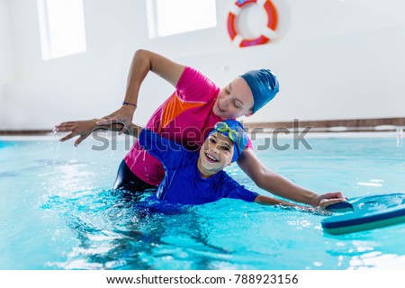 Boy having a swimming lesson with instructor Royalty-Free Stock Photo #788923156