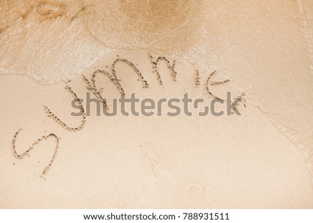Summer word is written on the beach sand