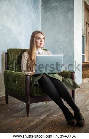 Portrait of Casual Young Woman with Laptop Surfing the Web at Home