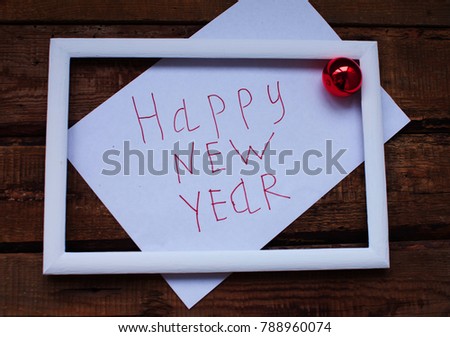 white frame on wooden background with text. Happy new year. 