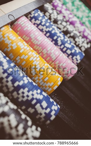 Casino / poker chips colorful gaming pieces lie on the game table in the stack. Background for gambling / casino, business, poker. many colorful casino chips. vintage photo processing. Soft focus