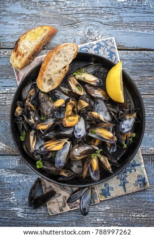 Traditional barbecue Italian blue mussel in white wine as top view in a casserole  Royalty-Free Stock Photo #788997262