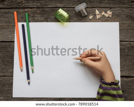 children's hand with a pencil on a sheet of paper