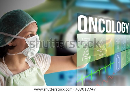 Oncology concept. Doctor using a futuristic touch screen concept computer with medical icons on it. Healthcare operation surgery room on background. Royalty-Free Stock Photo #789019747