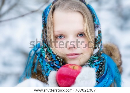 Young girl in Russian scarf in winter landscape