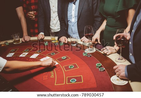 People / friends play poker roulette at the table in the casino. A group of young people at a roulette table with a tape measure. Table for gambling in a luxury casino. Vintage photo processing