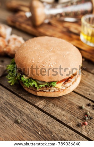 rustic composition with burger, cherry tomatoes, pepper on a wooden table
