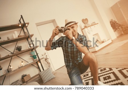 Man take a photo of pregnant woman in loft interior with old soviet camera.