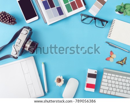 top view office desk workspace with smartphone, notebook, graphic tablet, keyboard, pantone books and mouse on blue background with copy space, graphic designer, Creative Designer concept