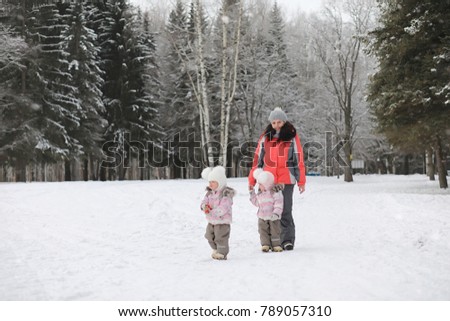 Children walk in the park in winter. Winter forest family with children on a walk. A cold winter day is a family walk.