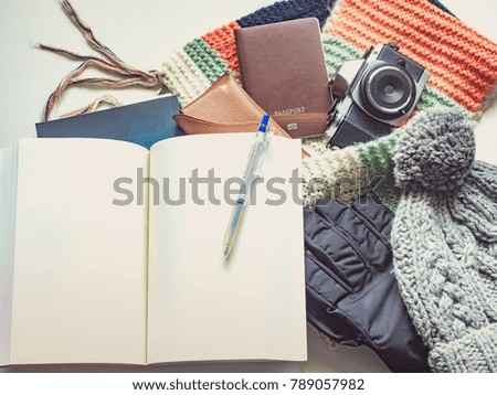 writer with book in winter season travel flat lay concept from  winter cloth item and passport, sunglasses with copy space and isolated white background