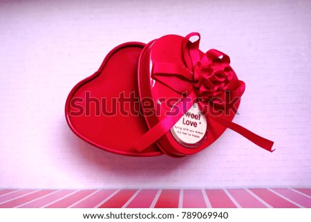 Heart-shaped box of pink ribbons on a white background.