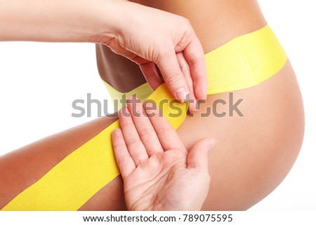 A picture of special physio tape put on injured thigh over white background