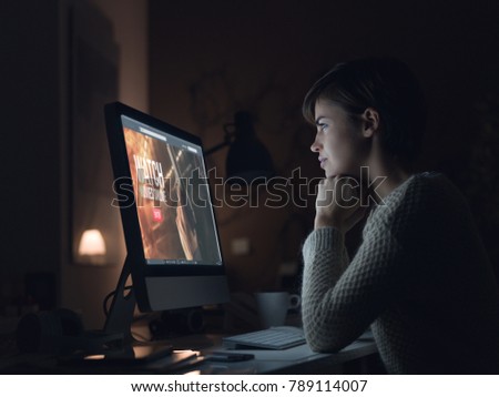 Young woman relaxing at home, she is watching movies and streaming online series Royalty-Free Stock Photo #789114007