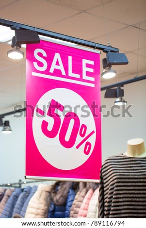 Sign in a clothing store with discount inscription SALE 50%.