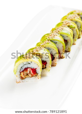 Avocado sushi roll with eel and tobiko on white plate. Green dragon sushi roll. Traditional Japanese food. Menu for restaurants or recipe illustration.