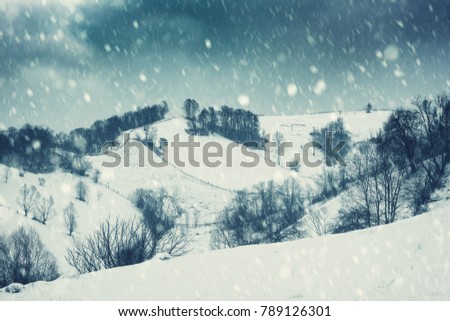 Dramatic winter landscape, mountain slope during blizzard. Holiday background, vintage image