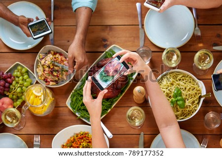 thanksgiving day, eating, people and technology concept - people with smartphones photographing food on table