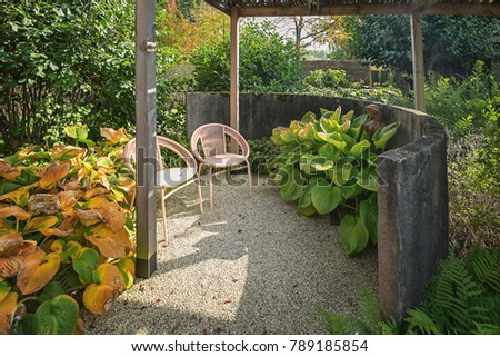 Two chairs to enjoy the sun in the corner of a beautiful autumn garden