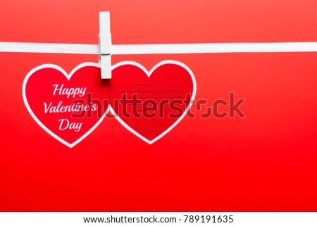 Greeting card with Happy Valentine's day words pinned on a rope on the red background.