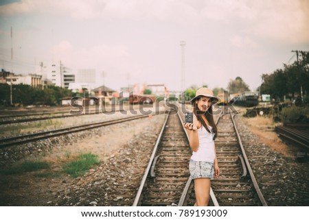 Portrait of beautiful asian woman  in A white T-shirt with camera in hand on the railway vintage style