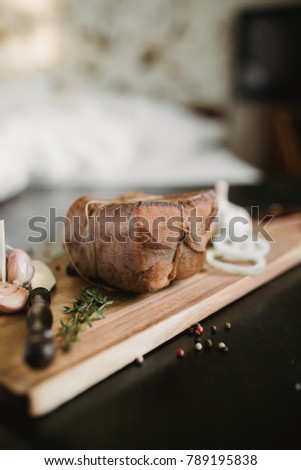 Chunk of salted smoked lard in gauze with a rope.Traditional Russian and Ukrainian meal.Healthy food with pranami spices, herbs, onion and garlic.Food photo for recipe or cookbook. Rustic clolor style