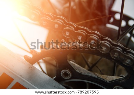 Motocross. motorcycle chain. wheel. dirt on a motorcycle.
A close-up of a dirty rear mud bike wheel.