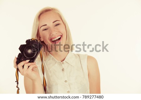 active young woman taking photos with retro camera isolated over white background