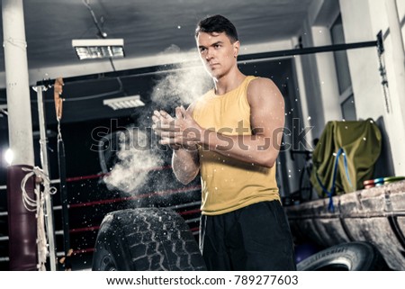 An athletic man is preparing for the exercises. Photos taken on an atmospheric old gym in a vintage atmosphere