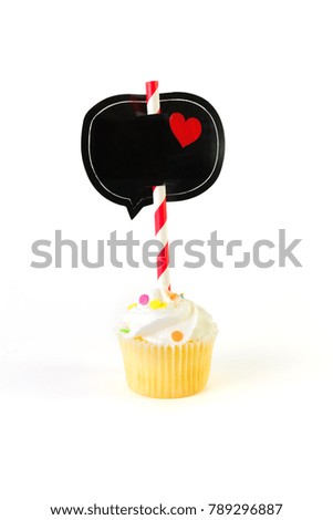 Mini frosted cupcake with black speech bubble and heart on striped stick. Isolated on white. Valentines, communication and love concepts