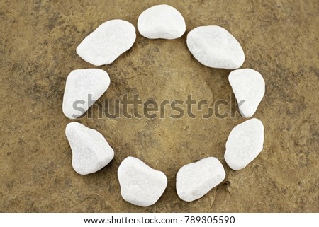 Circle with white pebbles on brown stone chunk