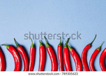 Red chili peppers arranged on a light blue background