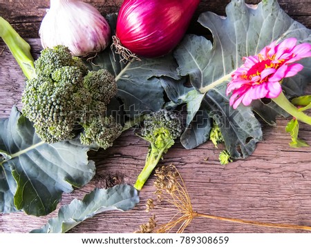   Beautiful  vintage photo  zinnia  flowers and broccoli cabbage   on a wooden background.Top view. Place for text.Dark vintage background with Spring  flowers. Selective focus.