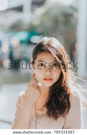 portrait of young beautiful Asian woman posing outdoor in sunlight