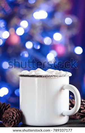 Enamel White Coffee Mug Cup of Cocoa Hot Drink Beverage with Marshmallow on Festive background with bokeh garland decoration