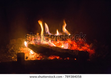 Fire flames with ash in fireplace, background, orange