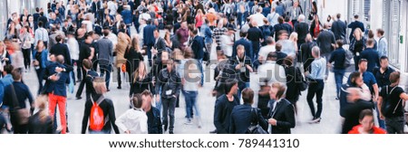 Crowd of anonymous blurred people at a trade show
