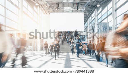 large crowd of anonymous blurred people at a trade show