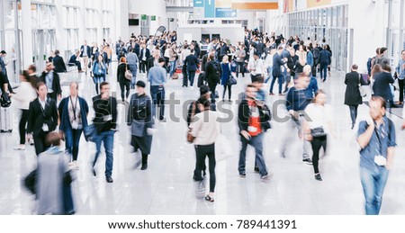 crowd of anonymous blurred people at a trade fair