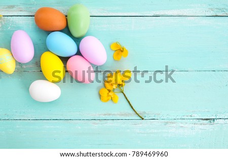 Colorful Easter eggs with flower on rustic wooden planks background in blue paint. Holiday in spring season. vintage pastel color tone. top view composition.