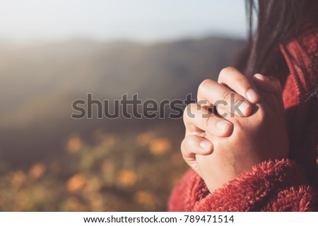 Woman hands folded in prayer in beautiful nature background with sunlight in vintage color tone Royalty-Free Stock Photo #789471514